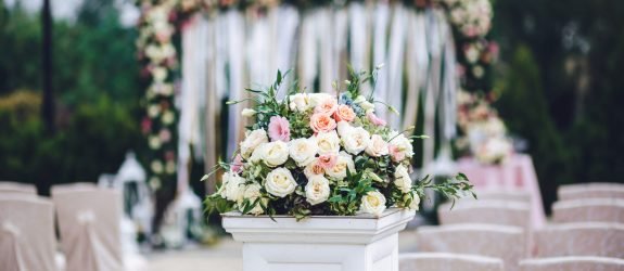 Column with rich bouquet of roses stands outside